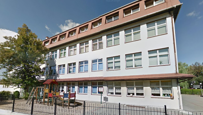 Współczesne zdjęcie. Przedstawia widok na budynek. Jest to Szkoła Podstawowa nr 1 im. Jana III Sobieskiego z Oddziałami Integracyjnymi w Kozach. 