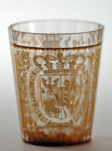 Szklaneczka królewicza Jakuba Sobieskiego - najstarszego syna króla Jana III. Na naczyniu umieszczono monogram właściciela "JLKP" pod koroną szlachecką, a po przeciwnej stronie zwieńczoną koroną królewską tarczę Rzeczypospolitej. Użyte motywy roślinne i zwierzęce służą nie tylko upiększeniu wyrobu, ale i podkreśleniu przymiotów godnych monarchy.