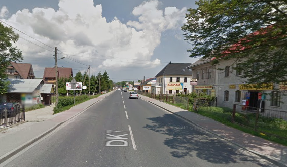 Współczesne zdjęcie. Przedstawia widok ulicy w mieście. Po prawej i lewej stronie pojedyncze budynki. Jest to Ulica Sobieskiego w Jabłonkach. 