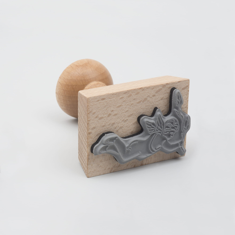 Drewniany stempel z pieczątką w kształcie amora. 