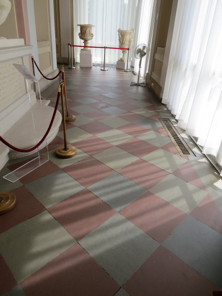 Kolorowe zdjęcie współczesne. Przedstawia korytarz pałacowy i dwukolorową posadzkę z piaskowca w Galerii Południowej w Wilanowie. 