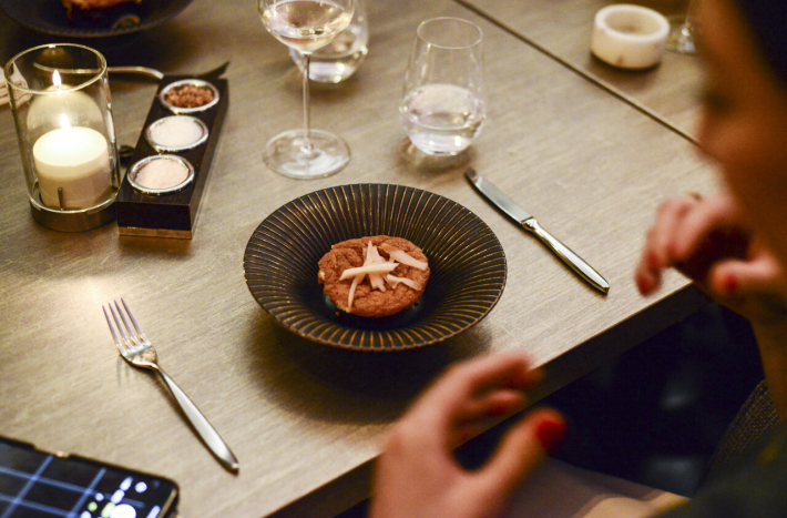 Ozdobne tanie na talerzu. Obok na stole są sztućce, świeczki, szklanka i kieliszek.